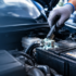 Mechanic cleaning corroded car battery terminal